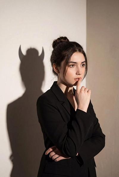 暗影恶魔角映衬沉思女性的内心矛盾肖像