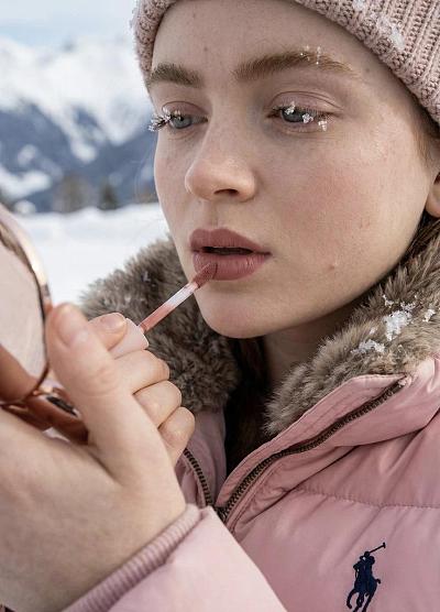 雪中少女涂抹唇彩的精致瞬间
