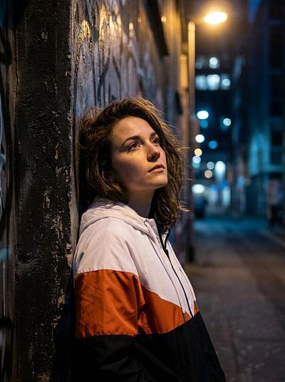 夜巷中倚墙沉思的年轻女子肖像
