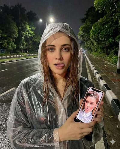 雨夜街头女子穿透明雨衣持粉色iPhone自拍，屏幕显示同款照