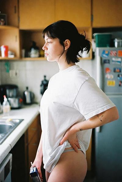 日常厨房中的年轻女性侧影，自然生活感写真