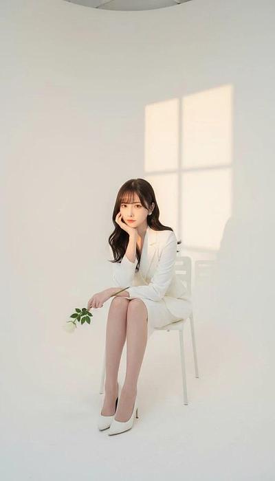 影楼白裙女性正面肖像（手托下巴持白玫瑰，窗影背景）