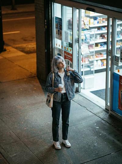 夜街高角度街拍：少女独站便利店前，手持咖啡，随性自然。