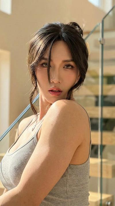 高端生活肖像：女性肩托下巴，浅灰背心，银链吊坠，玻璃栏杆背景
